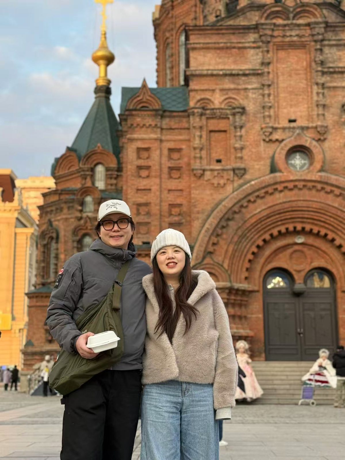 John and Andrea in front of a brick cathedral
