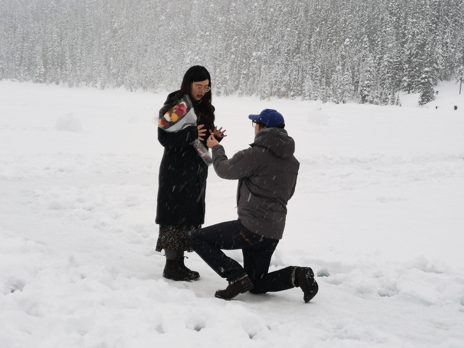 John kneeling in the snow, proposing to Andrea